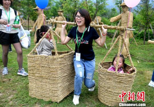 游客在“创意稻草部落”打卡，体验农耕的乐趣。　吕明 摄