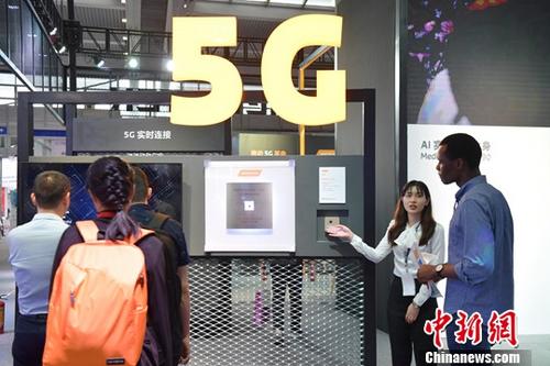 资料图：海内外客商关注5G通讯业务。/p中新社记者 陈文 摄