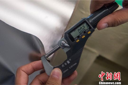 太钢精密带钢公司工作人员用精密仪器测量厚度为0.02毫米的不锈钢。　韦亮 摄