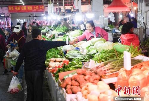 资料图：重庆一农贸市场内菜商正在忙碌卖菜。/p中新社记者 陈超 摄