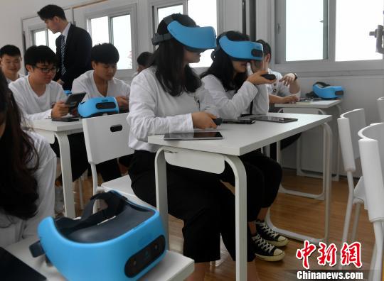 图为学生用VR眼镜在集装箱教室上课。　吕明 摄