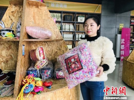 图为甘肃成县“电商中心”工作人员展示“网货”。(资料图) 闫姣 摄