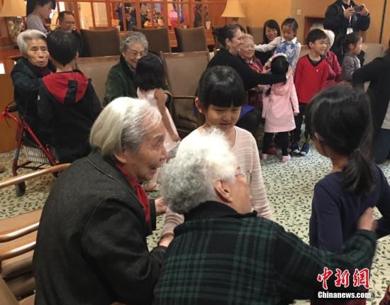 资料图：在北京双井恭和苑养老院，老人们与幼儿园小朋友一起做游戏。/p中新社记者 杜燕 摄