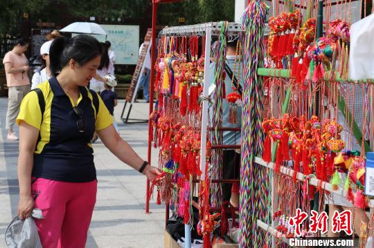 端午节间，一名游客在洛阳龙峪湾景区挑选香包。　李彦 摄