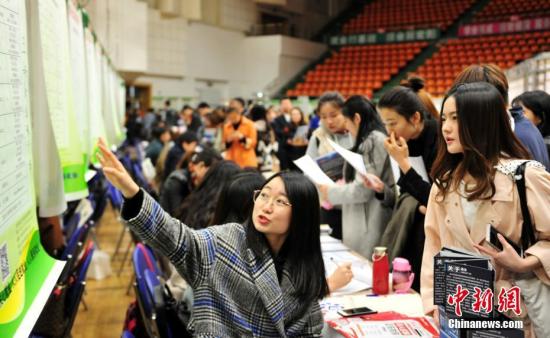 资料图：4月11日，沈阳师范大学学生在双选会现场寻找合适的职位。/p中新社记者 于海洋 摄