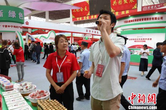 展会现场，嘉宾品尝枸杞深加工产品“枸杞原浆。　李佩珊 摄