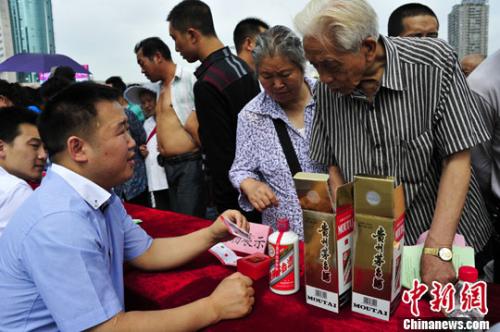 市民街头学习辨别真假茅台。/p中新社发 张元 摄