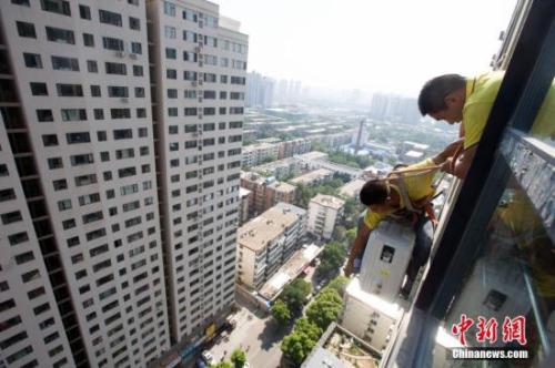 资料图：在山西太原，空调安装工程师顶着酷暑高温，为市民安装空调。/p中新社记者 张云 摄