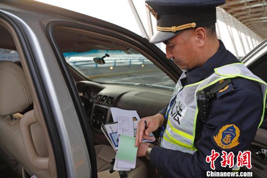 资料图：民警核查网约车运营资质。殷立勤 摄